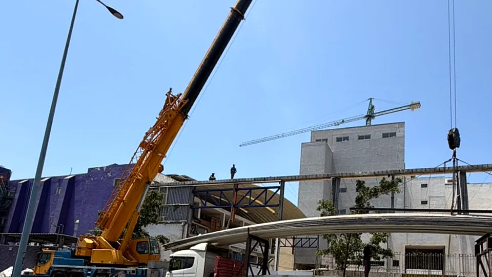 Grue mobile en cours de levage sur un chantier de charpente métallique CHARMETAL