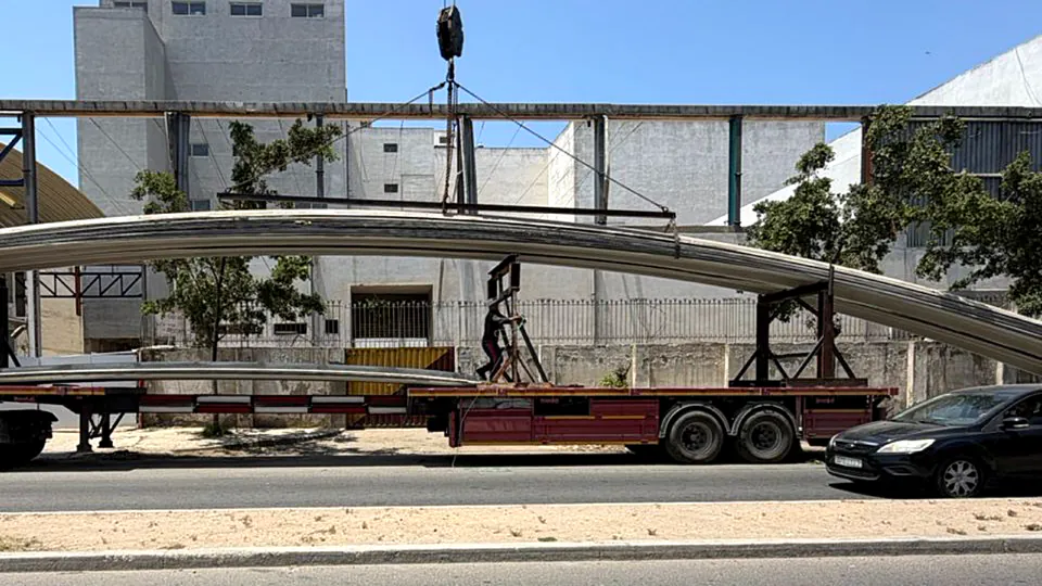 Arc métallique de grande portée sur remorque, élingué avant levage — chantier CHARMETAL